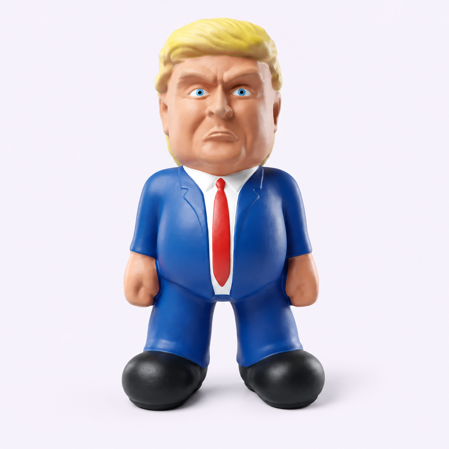 Front view of the Trump dog toy with yellow hair, blue suit, red tie and black shoes on a pale studio background.