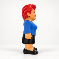 Side view of the MEGA Pauline Hanson dog toy showing swept red hair, dark earring, blue jacket and black skirt.