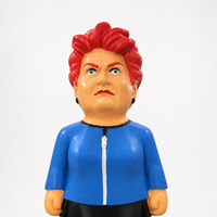 Close-up of the MEGA Pauline Hanson dog toy showing its painted face, red hair and blue jacket with white zip detail.